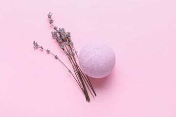 Bath bomb and lavender flowers on color background