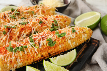 Board with tasty Elote Mexican Street Corn on table, closeup