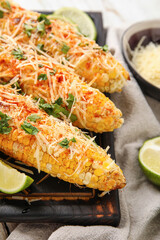 Board with tasty Elote Mexican Street Corn on table, closeup
