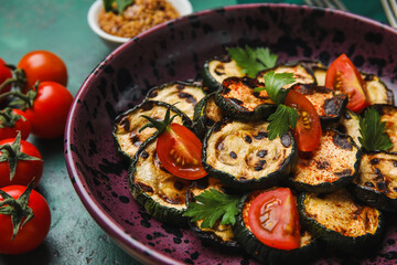 Plate with tasty grilled zucchini on color background, closeup