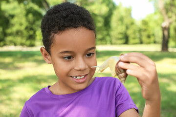 Little African-American boy with snail outdoors © Pixel-Shot