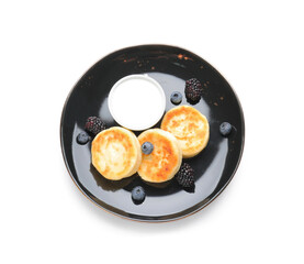 Plate with cottage cheese pancakes on white background
