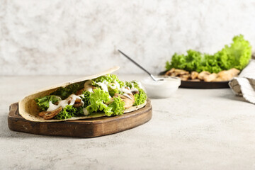 Wooden board with tasty Fajitas on light background
