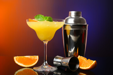 Glass of tasty orange margarita cocktail on dark color background