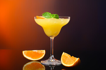 Glass of tasty orange margarita cocktail on dark color background
