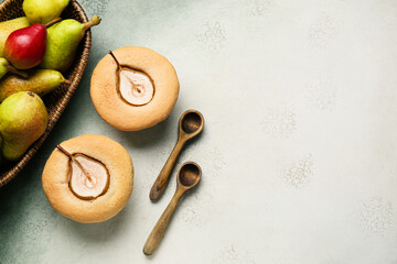Tasty pear pot pies and basket with fresh fruits on light background