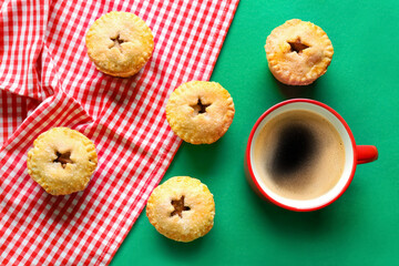 Delicious mince pies and cup of coffee on color background