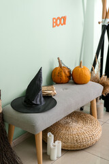 Ottoman with witch's hat and pumpkins in hallway decorated for Halloween