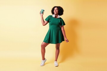 young black woman with afro hair hold a coffee cup.