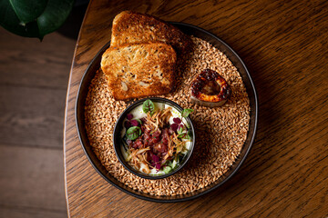 Beautifully served raw meat tartare with a baked pipe bone and fried bread