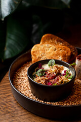 Raw beef tartar in a fancy restaurant on a wooden table, neat elegant commercial photography