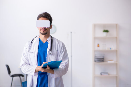 Young male doctor wearing virtual glasses in the clinic