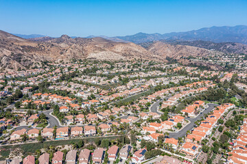 Aerial view of a southern California neighborhood surrounded by hills and mountains - obrazy, fototapety, plakaty