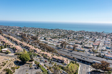 Aerial view of a coastal community, freeway, and ocean.