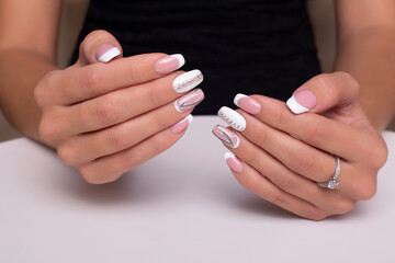 Beautiful female hands with wedding manicure nails with ring on white background