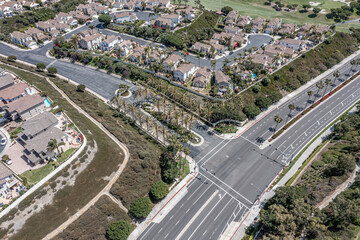Gated entry to an upscale California neighborhood, aerial view of street lined with palm trees.