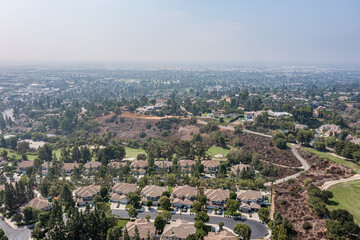 Fototapeta na wymiar Aerial View of a Suburban California Community Near a Golf Course on a Foggy Day