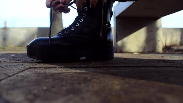 The girl tying shoelaces on winter boots