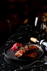 French glazed meat on black marble table in dark empty restaurant