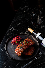French glazed meat on black marble table in dark empty restaurant
