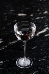 A shot of dry vodka on a black bar counter, posh, minimalist elegant photo