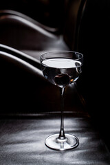 Single dry liquor shot on a black leather, minimalist elegant commercial photo