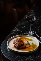 Fine dining steak with meat juice and sprouts on a black marble table, texture visible