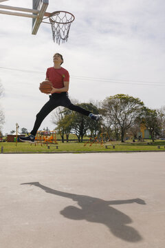 Young Basketball Player Dunking A Basket