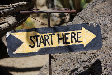 Arrow sign START HERE at the beginning of a trail