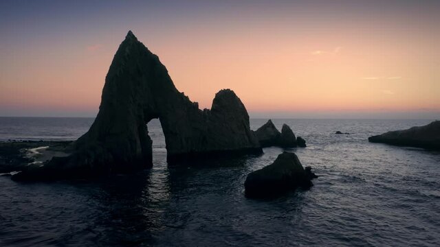 Aerial: Shark Fin rock at sunset on Martin's Beach, California, USA