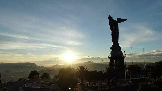 Aerial: Virgin of El Panecillo statue morning sunrise in Quito Ecuador, zoom out