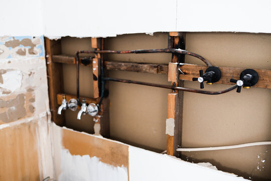 laundry room renovation with plaser walls interior exposed with visible electricity wires and copper pipes, home renovations and tradesman work