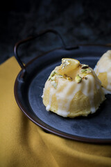 Lemon cake with sugar sweet icing on yellow and black background. Cake with citrus, poppy, traditional american cuisine in dark tone