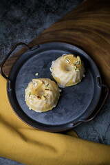 Lemon cake with sugar sweet icing on yellow and black background. Cake with citrus, poppy, traditional american cuisine in dark tone