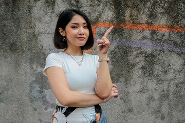 Thinking gesture of Asian beautiful girl pointing beside with white shirt.
