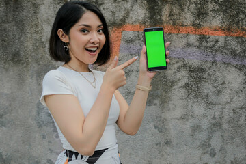 Happy and smile young asian women showing green blank screen.