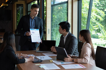 Diverse group of business people meeting in office discussing business brainstorming meeting marketing report