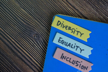 Diversity, Equality, Inclusion write on sticky notes isolated on Wooden Table.