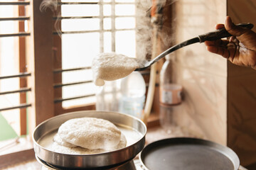 Idli or idly, savory rice cake from India, breakfast foods on South. Woman cooking at home, hot food with steam