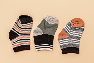 Different socks beige background with copy space. Flat lay. Top view.