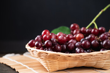 Fresh red grape in a basket with black background, Organic tropical fruit