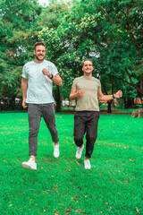 gay couple running on the grass in a park