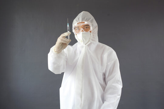 Asian Doctor Wearing PPE Protective Suit Posing With Holding Syringe