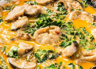 Cooking catfish curry  with coconut milk and shrubby basil, Thai famous food.