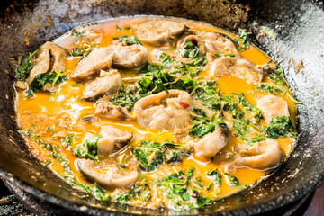 Cooking catfish curry  with coconut milk and shrubby basil, Thai famous food.