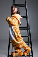 Cute Asian little girl wearing giraffe pajamas playing indoors