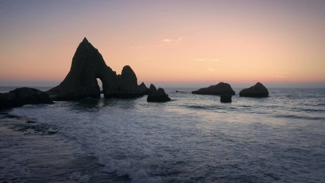 Aerial: Shark Fin rock at sunset on Martin's Beach, California, USA