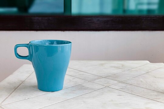 The Coffee Mug Placed On The White Plastic Table Top