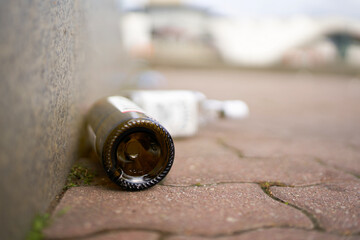 empty liquor bottles on a sidewalk at Alexanderplatz in the center of Berlin