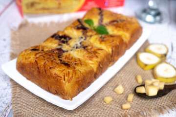 Pineapple bread, the typical food of the city of Tegal, Indonesia, decorated with banana and cheese on white plate